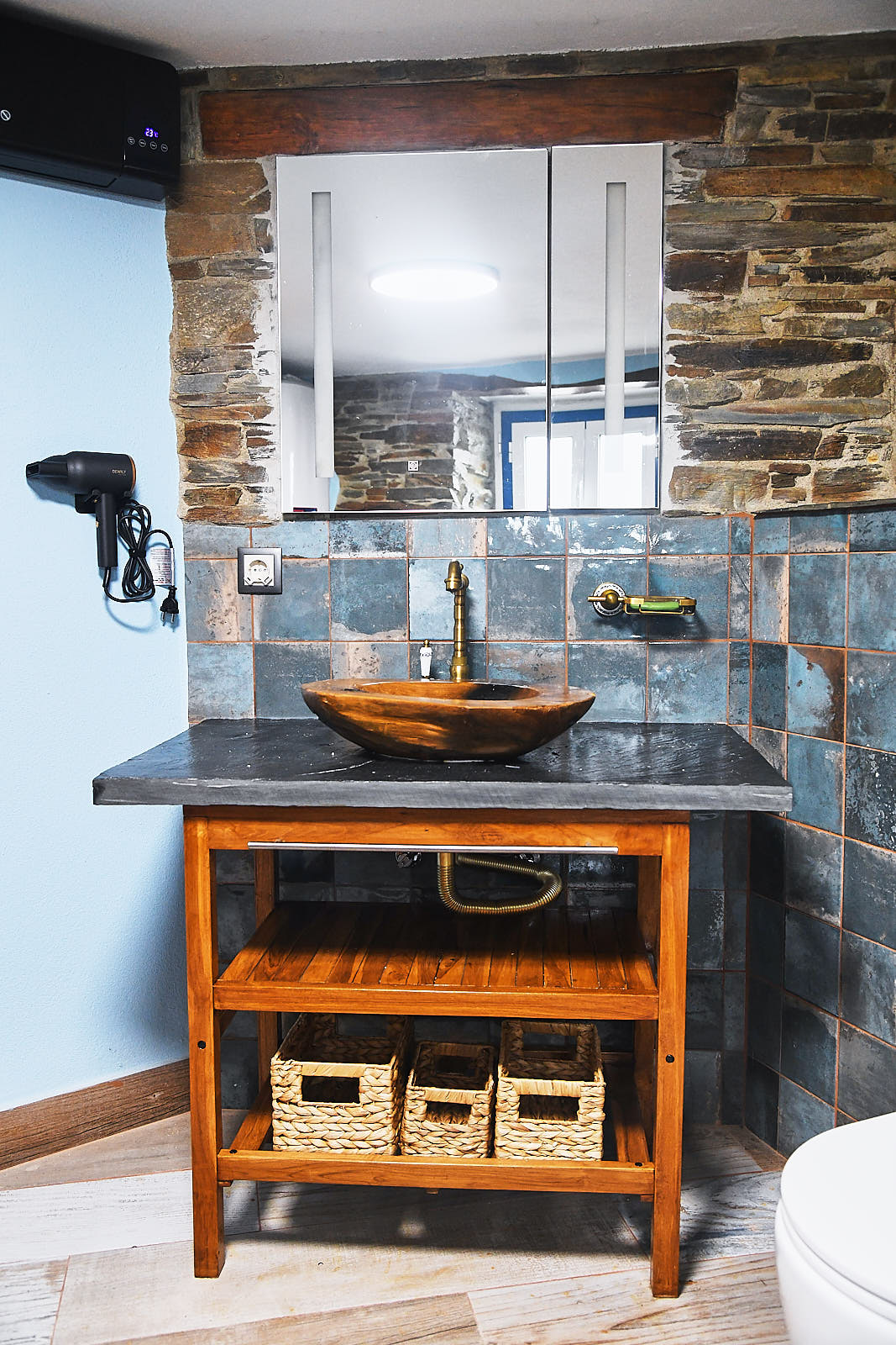 Wooden bathroom vanity with a carved stone sink