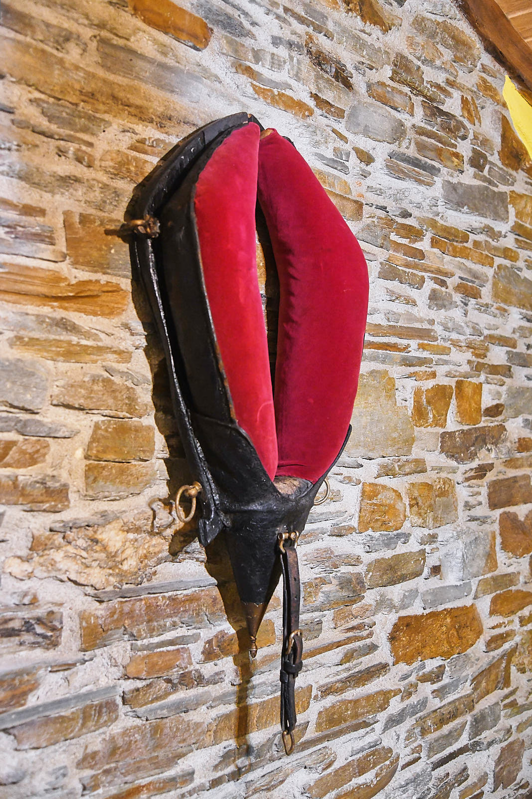 Traditional red bellows mounted on the exposed schist wall