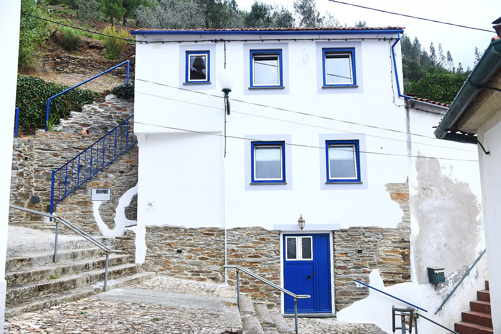 Casa da Égua exterior with white façade, blue windows and blue entrance door