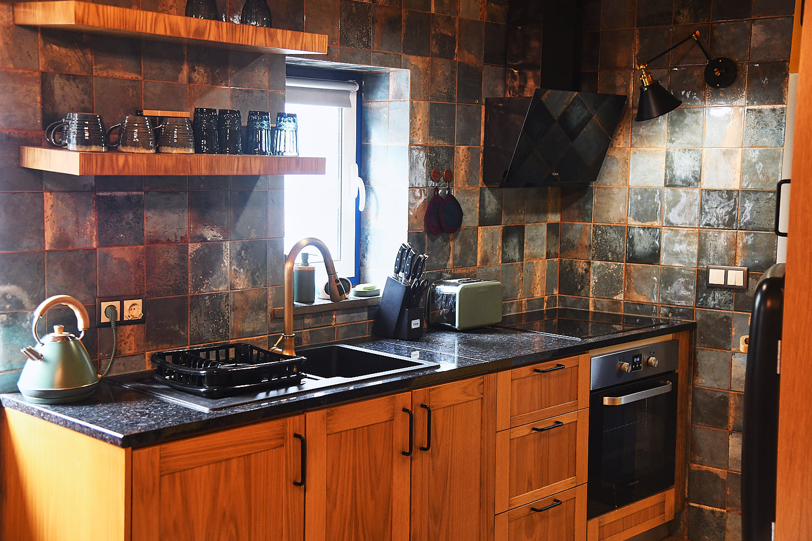 Casa da Égua kitchen with copper-glazed tiles and wooden cabinets